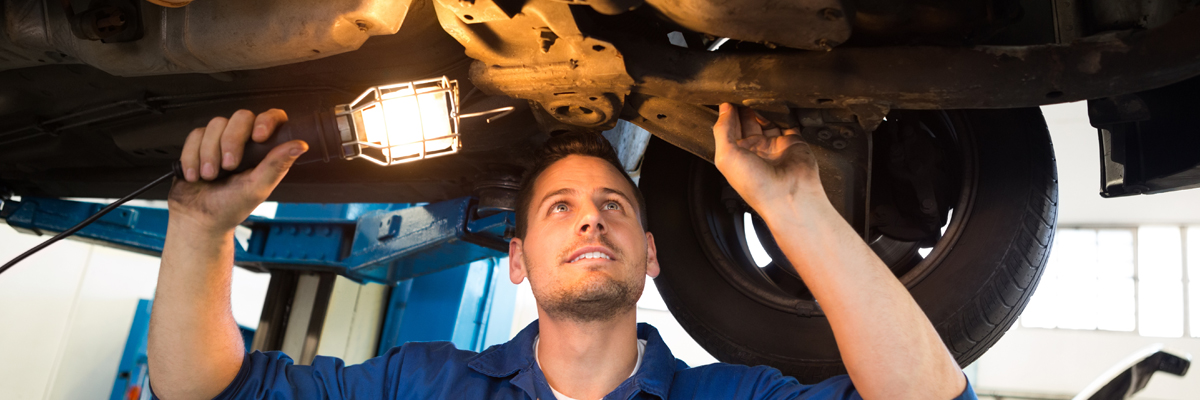 Mechanic looking under a vehicle doing an MOT Test - MOT Testing Bathgate